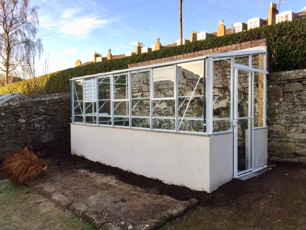 Small white lean-to greenhouse