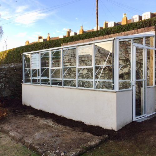 Small white lean-to greenhouse